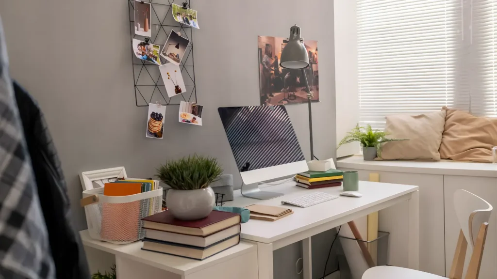 Aesthetic Home Office Ideas - Bright, airy aesthetic home office with a white desk, a linen desk chair, floating shelves with plants and books, and warm natural light streaming through sheer curtains