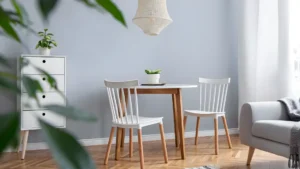 Space‑Saving Furniture Ideas for Small Homes and Apartments (2026 Guide) 7 A drop-leaf dining table with one leaf up in a small kitchen-dining area, set for two, showing how it saves floor space when folded.