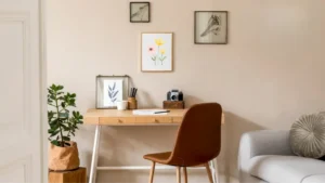 Feminine minimalist Japandi-inspired home office with light oak desk, linen chair, single ceramic vase, and warm diffused lighting in a calm airy room