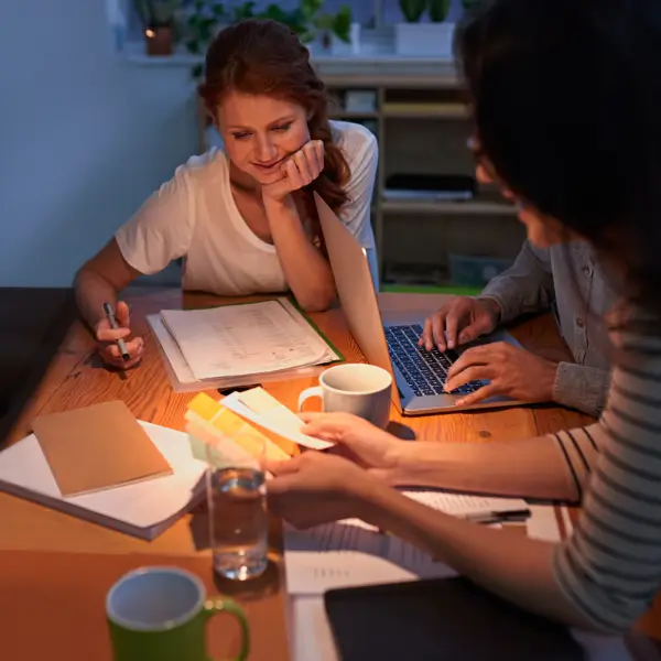 Two women working together at a desk, planning home office and decor ideas
