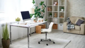 Feminine work-from-home nook in a studio apartment with a white desk near a window, a gallery shelf, and warm lighting